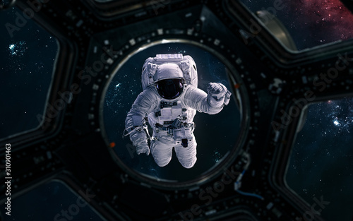 Fototapeta Naklejka Na Ścianę i Meble -  Astronaut overboard a spaceship. View from porthole. Science fiction. Elements of this image furnished by NASA