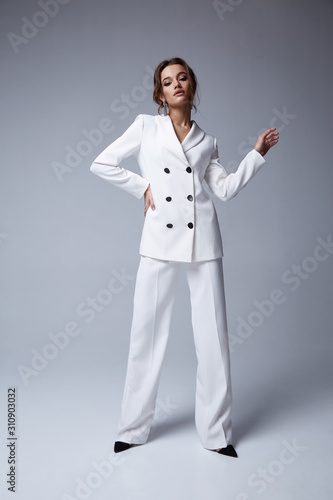 Fotografía Fashion beauty model curly dark hair style beautiful sexy pretty woman perfect skinny body shape cosmetic makeup face wear clothes white trend suit silk pants jacket accessory shoes studio background