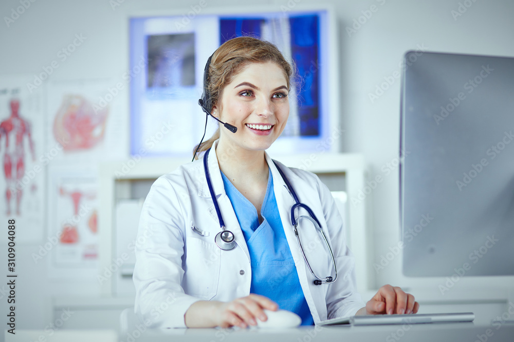 Portrait of a happy smiling young doctor in headset in office Portrait of a happy smiling young doctor in headset in office