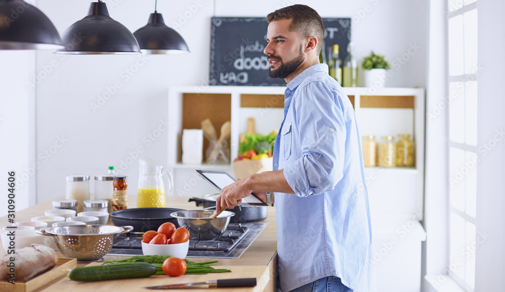 Smiling and confident chef standing in large kitchen Smiling and confident chef standing in large kitchen