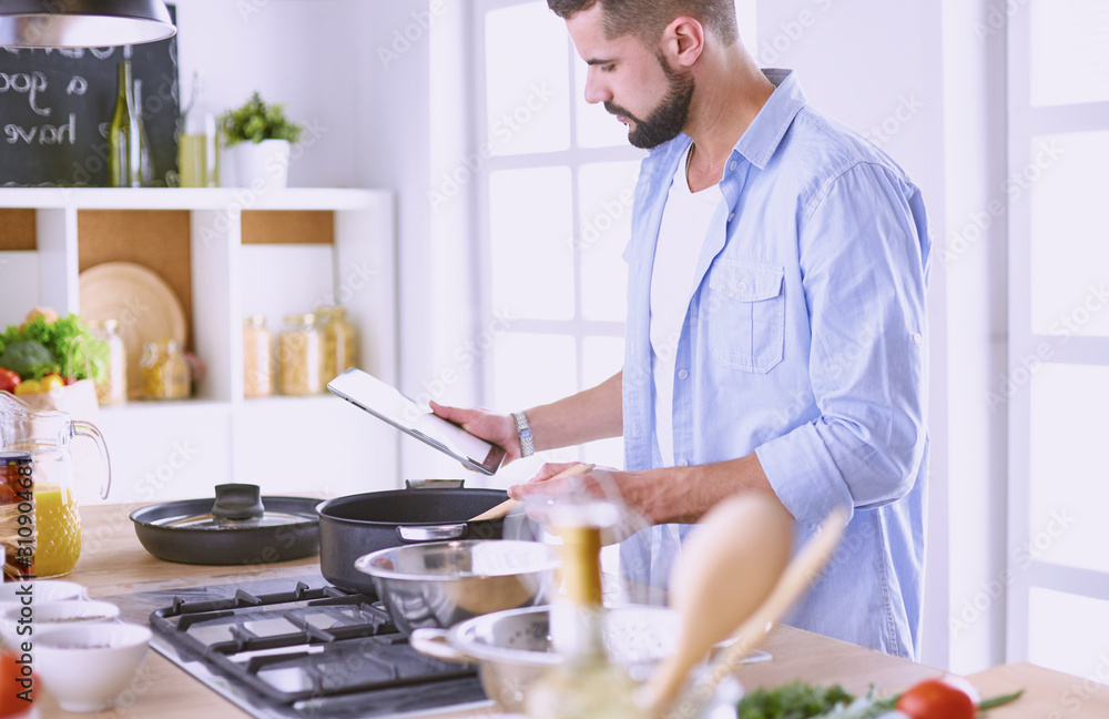 Smiling and confident chef standing in large kitchen Smiling and confident chef standing in large kitchen