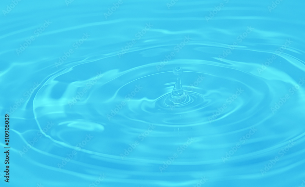 Closeup Water drop falling on the surface of the water and beautiful circular wave ripple, fresh natural mineral water drink water concept Closeup Water drop falling on the surface of the water and beautiful circular wave ripple, fresh natural mineral water drink water concept