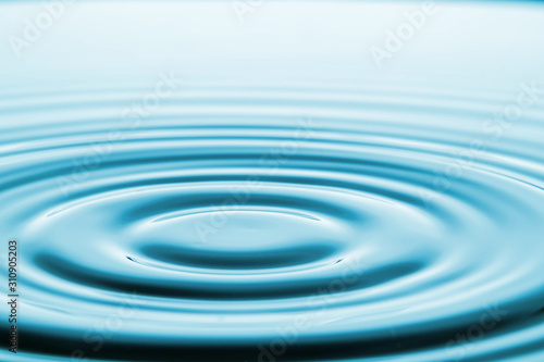 Closeup Water drop falling on the surface of the water and beautiful circular wave ripple, fresh natural mineral water drink water concept