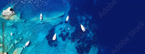 Aerial drone photo of sail boats docked in turquoise exotic island bay with crystal clear sea © aerial-drone
