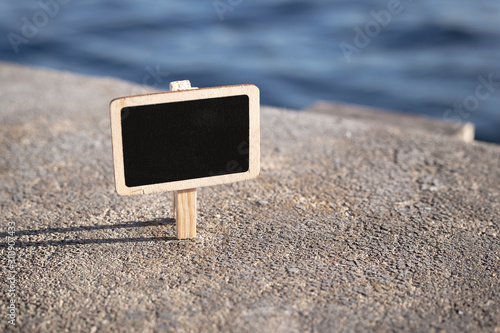 Blank wooden blackboard label in front seaside