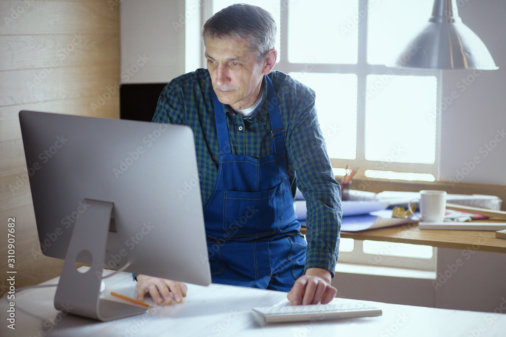 Engineer carpenter working on laptop and sketching project