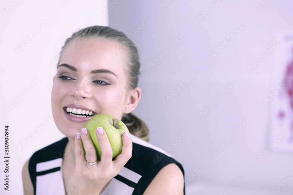 Young beautiful smiling girl with a green apple in hands Young beautiful smiling girl with a green apple in hands