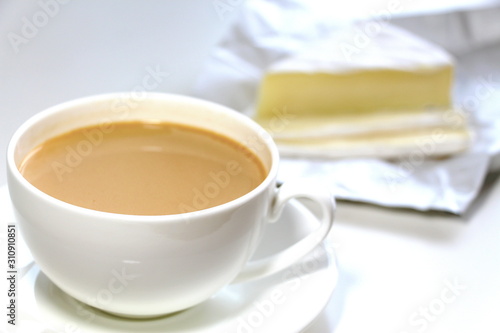 Coffee with milk. White cup. Soft brie cheese. Morning. Tasty breakfast.