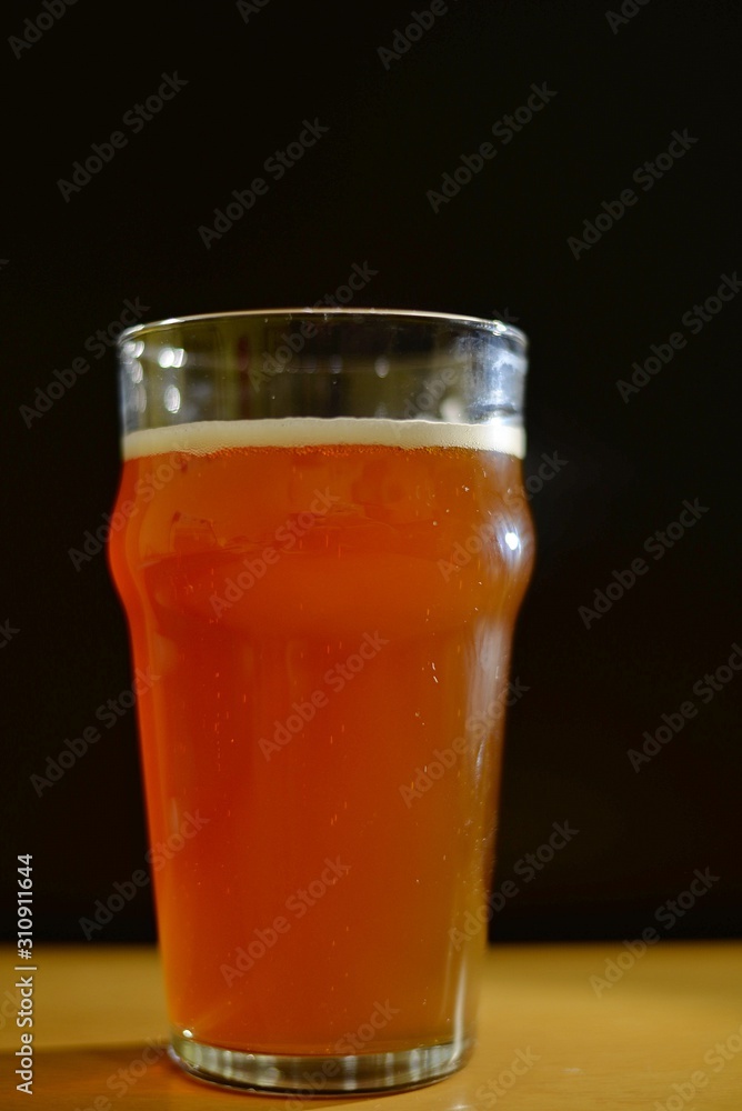 Glass of craft beer with foam black background Glass of craft beer with foam black background