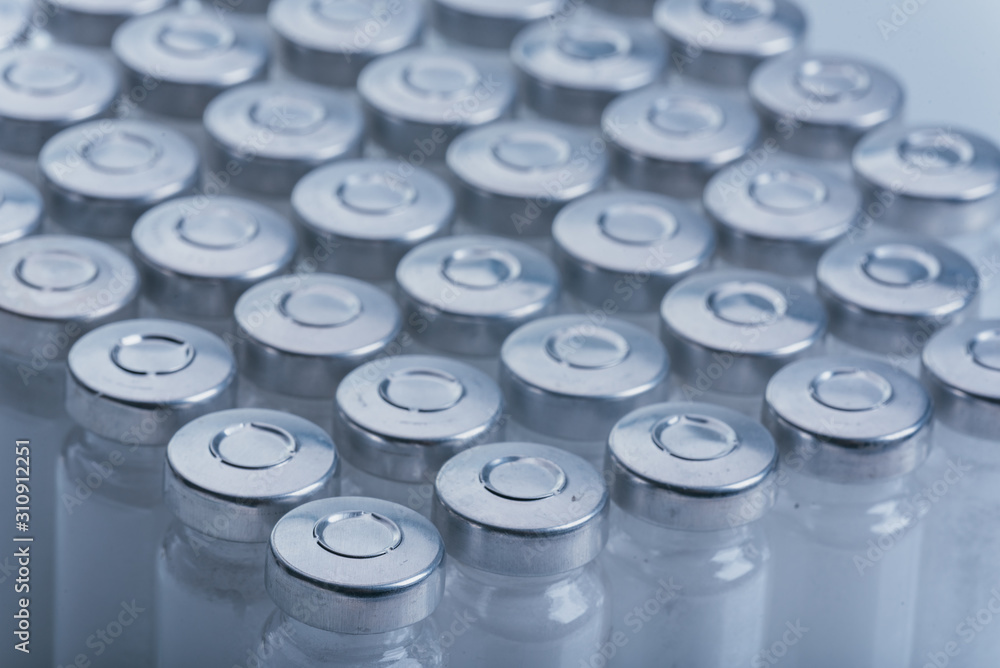 Glass medical ampoule vial for injection. Medicine is dry white drug penicillin powder or liquid with of aqueous solution in ampulla. Close up. Bottles ampule with aluminum cap on backgrounds gray. Glass medical ampoule vial for injection. Medicine is dry white drug penicillin powder or liquid with of aqueous solution in ampulla. Close up. Bottles ampule with aluminum cap on backgrounds gray.