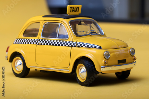 Yellow retro toy taxi on yellow background