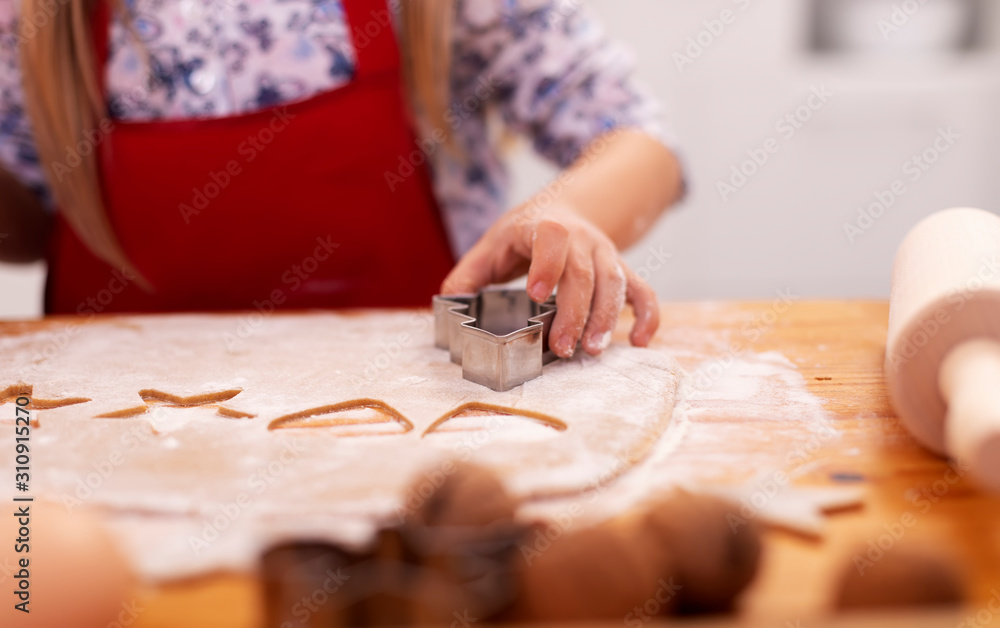 Little girl hand cutting gingerbread cookies from dough Little girl hand cutting gingerbread cookies from dough