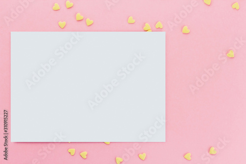 card on a background of heart-shaped confectionery confetti on a pink background copy space. Yellow hearts. © Марина Красавина