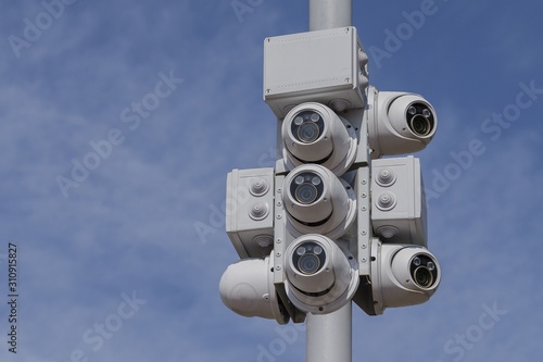 Street CCTV cameras against the blue sky.