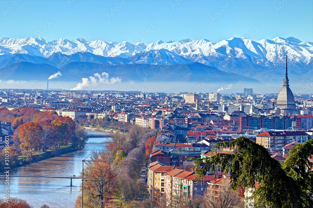 Obraz premium Aerial panoramic winter view on Turin city center with Mole Antonelliana, modern skyscrapers and other buildings, clear blue sky morning with Alps full of snow on background