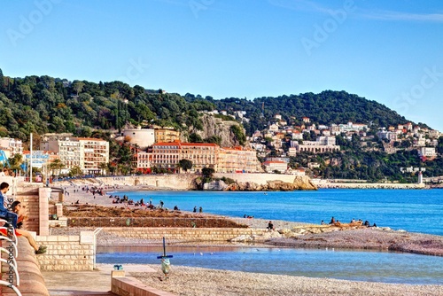 Nice, France - December 1, 2019: view of the beach and walkway promenade on a clear winter day © Marco