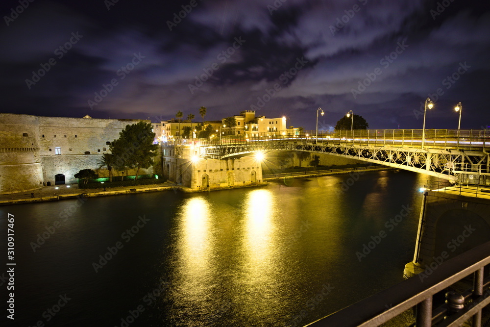 Fototapeta premium Night view of Castello Aragonese in Taranto, Italy. Officially called the Castel San Angelo, it was built on the site of older fortifications dating to Greek occupation