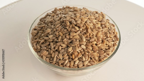 Nuts sunflower rotate are on a table in a plate. Snack in transparent dish on an isolated white background are spinning moving. Delicious and healthy protein-rich diet food. photo