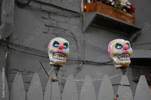 weird clown heads on a fence