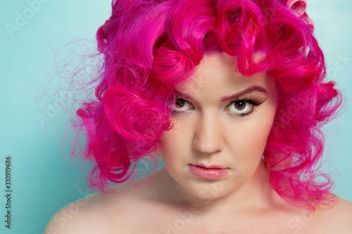 Portrait of a pink hair woman over colored background © moodboard