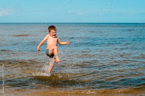 boy swimming in the sea, jumping in the waves of the ocean on the beach