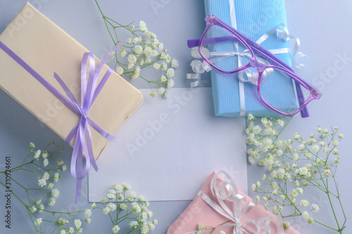 Cute gift boxes and flowers on color background