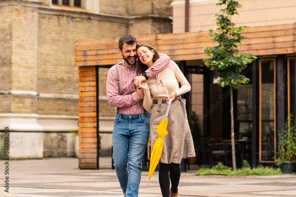 A man and a woman hugging while walking with holding hands fingers entwined. A man and a woman hugging while walking with holding hands fingers entwined.