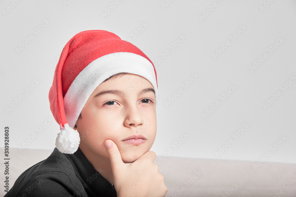 schoolboy kid in Santa hat difficult choice of purchase schoolboy kid in Santa hat difficult choice of purchase
