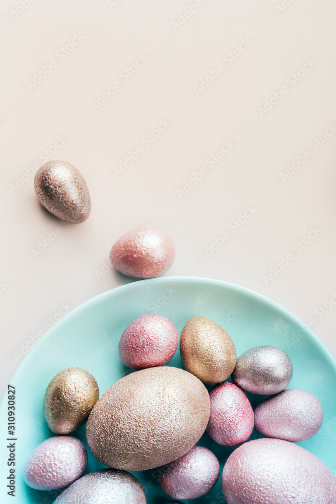 Colored painted pearl chicken and quail eggs of pink, silver, golden color on a blue mint plate pastel background. Minimalistic creative neo easter festive vertical flat lay. Copyspace for text Colored painted pearl chicken and quail eggs of pink, silver, golden color on a blue mint plate pastel background. Minimalistic creative neo easter festive vertical flat lay. Copyspace for text