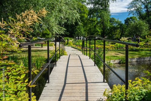 Obraz na płótnie View over a small walking path in the botanical garden with blooming flowers, Uppsala, Sweden w salonie