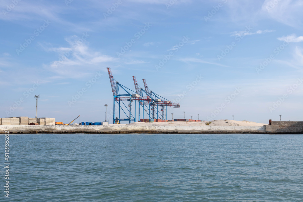 Cargo cranes at the sea docks. Unloading port.