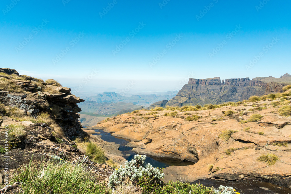Landscape of river and amphitheatre behind on the plateau of drakensberg mountains in South Africa