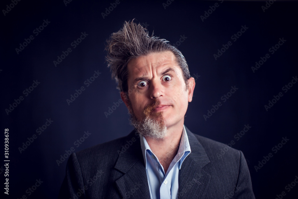 Half bearded man wearing suit in front of black background. People and skin care concept