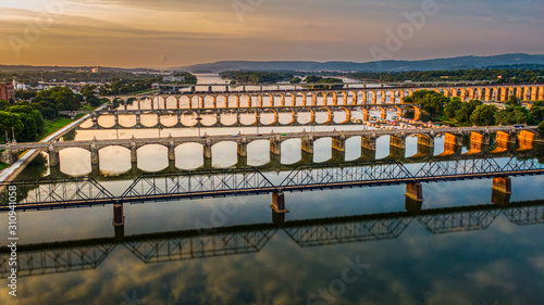 Many bridges over river in sunset, Harrisburg, Pennsylvania, Susquehanna river crossings aerial view, dramatic evening reflection in water, scenic American vista