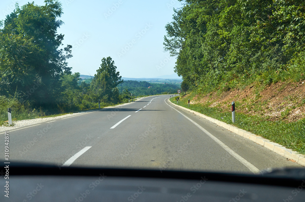 Fototapeta premium Country road going through a picturesque country landscape during a spring day