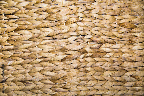 Background braided algae hyacinth yellow-brown with a beautiful weave in the form of braids. Backgrounds, design, structures.
