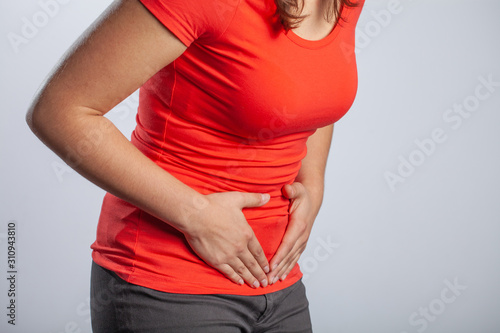 Young woman holding her tummy and suffering from menstrual cramps