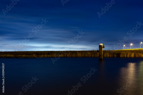 City skylight behind a dyke in a harbour in Bruinisse, the Netherlands