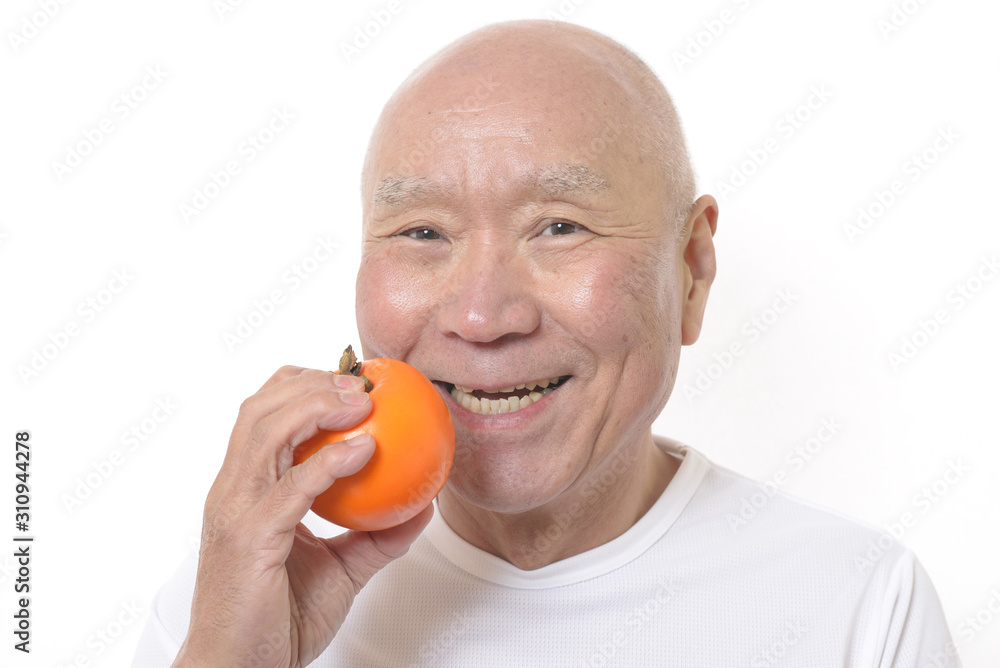 柿を食べる笑顔のシニア 柿を食べる笑顔のシニア