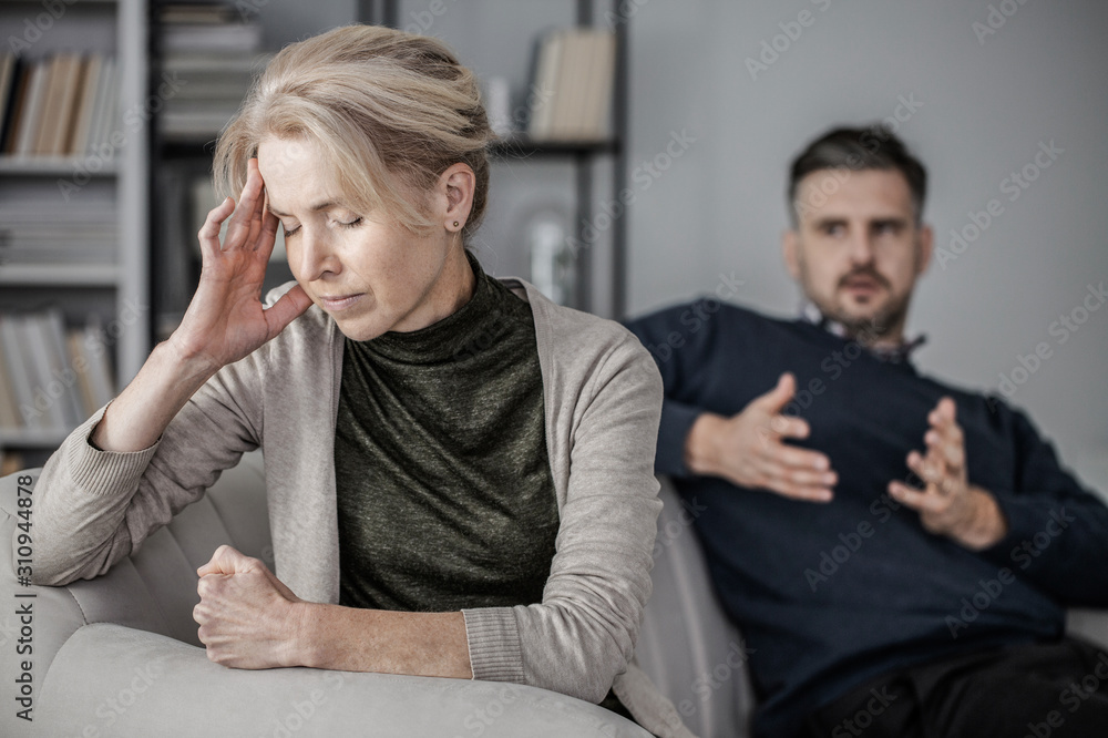 Senior depressed and tired wife with a headache in the middle of a conflict with a cheating husband Senior depressed and tired wife with a headache in the middle of a conflict with a cheating husband