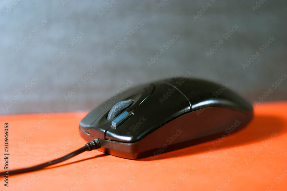 Black computer mouse on a red-black background Black computer mouse on a red-black background