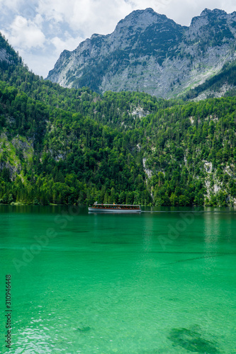 A tourist ship is cruising over the green lake Koenigssee (Königssee) in Bavaria, Germany © Tom H