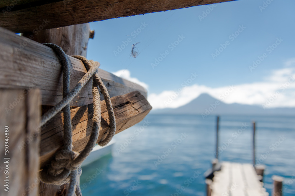 Pier tied with rope as a beautiful volcano is in the background
