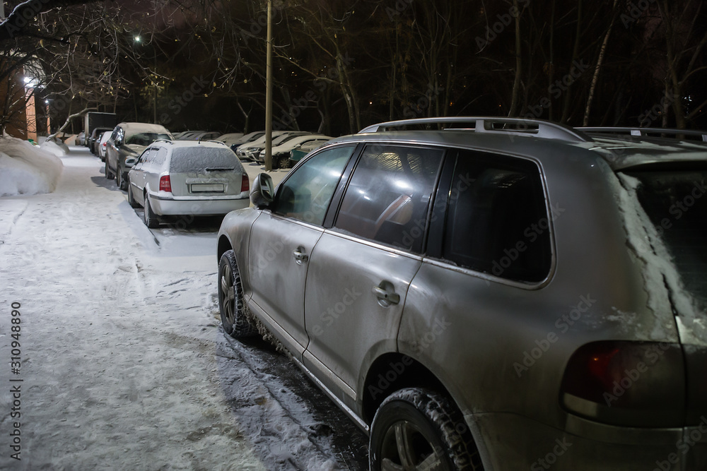 Cars in a parking lot on a winter night at a  building