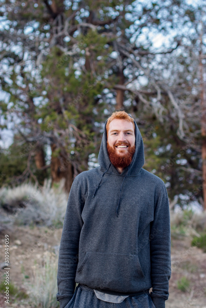 Red hair male model in a hoodie smiling towards the Camera, Big Bear Lake, USA Red hair male model in a hoodie smiling towards the Camera, Big Bear Lake, USA