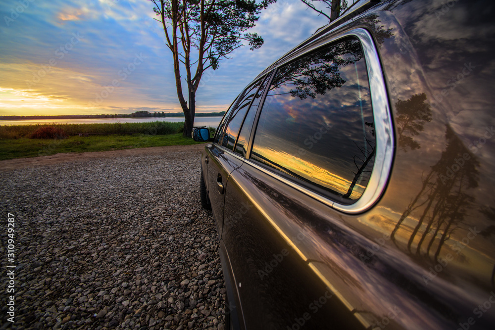 Car by the river at sunrise