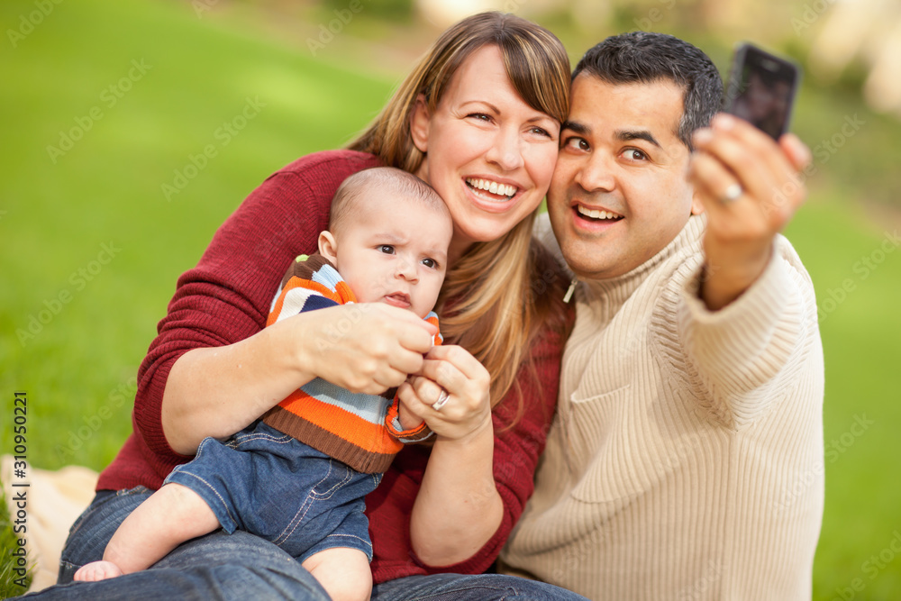 Happy Mixed Race Parents and Baby Boy Taking Self Portraits at the Park Happy Mixed Race Parents and Baby Boy Taking Self Portraits at the Park