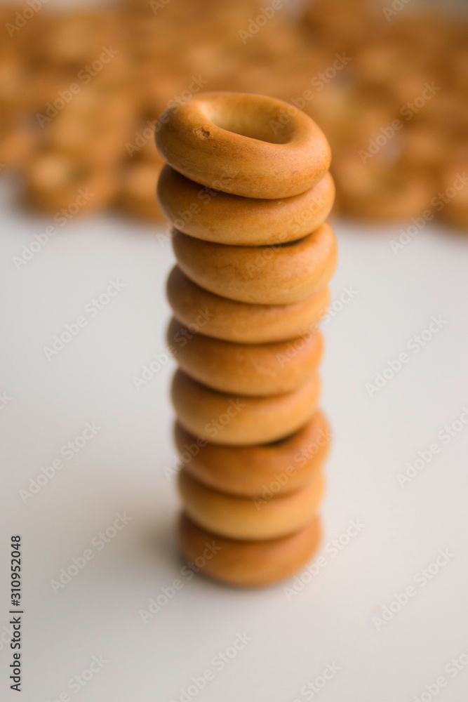 many bagels stacked on top of each other on a white kitchen table close-up many bagels stacked on top of each other on a white kitchen table close-up
