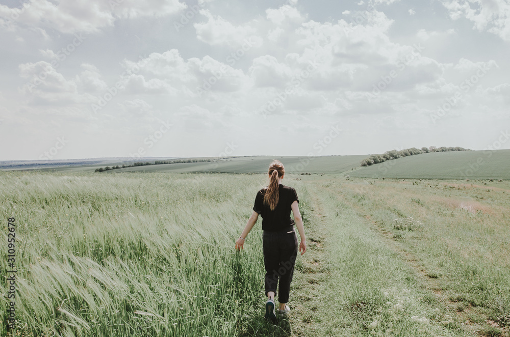 a woman walking in green field