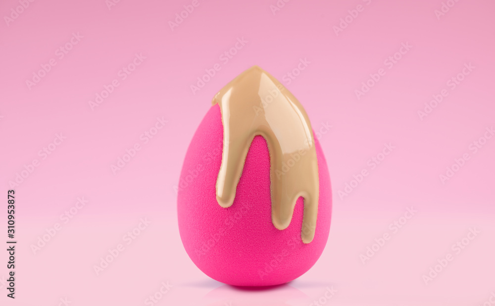 Makeup liquid foundation pouring on make-up blender sponge, closeup. Applying Foundation beauty facial cosmetics, tool for perfect make up. Dripping bb cream or concealer, over pink background